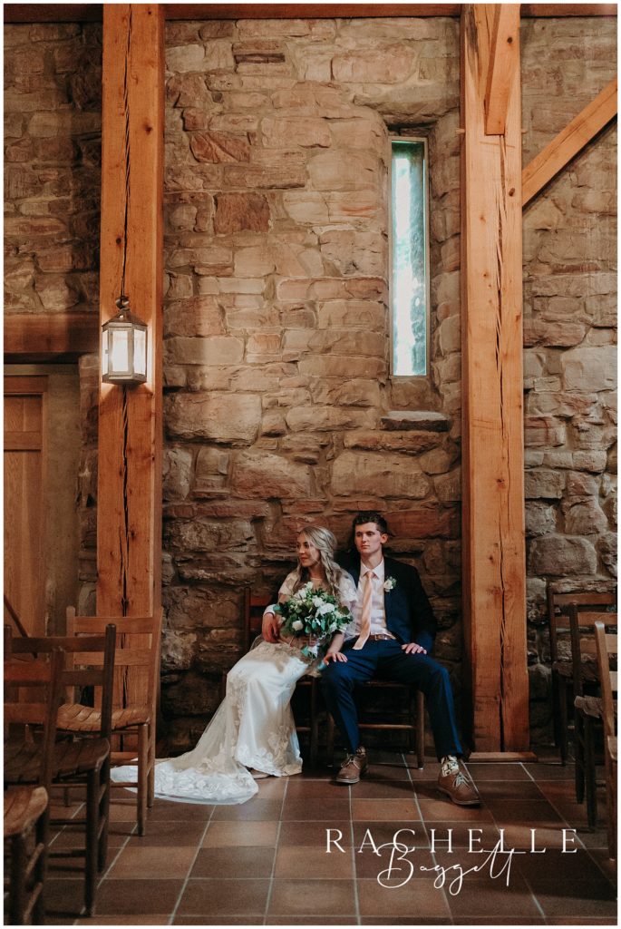 bride and groom lean against wall indoors