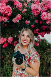 woman smiles and holds camera and is a photographer in evansville Indiana