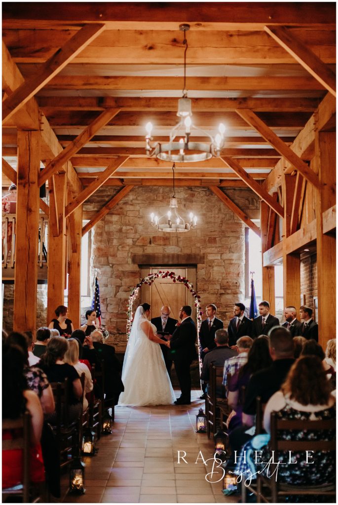 A bride and groom stand at the altar