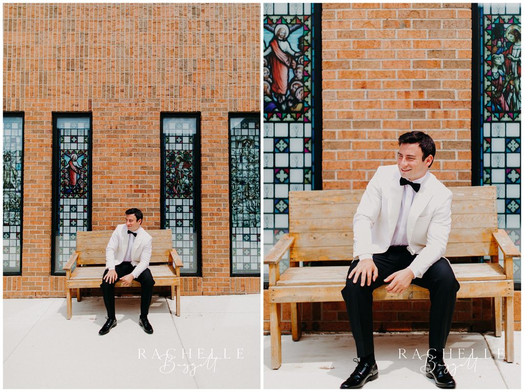 a groom sits on a bench outside of St. Joseph Catholic Church