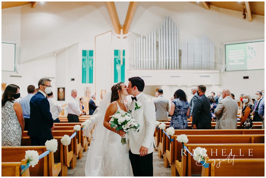 a bride and groom kiss in st. Joseph Catholic Church