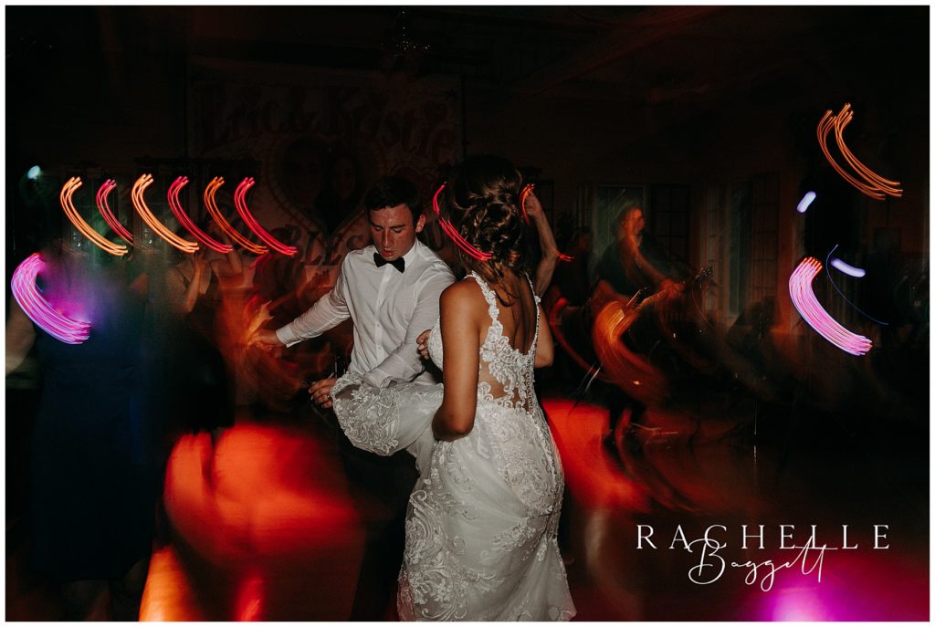 a bride and groom dance at camp tamarack in brighton michigan