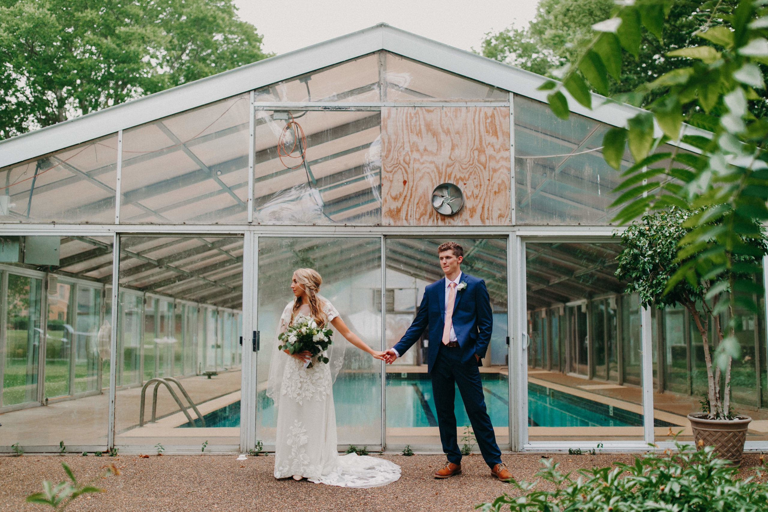 man and woman stand in front of greenhouse
