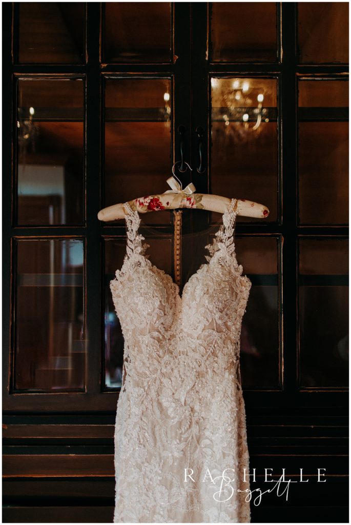wedding dress hanging on a door.