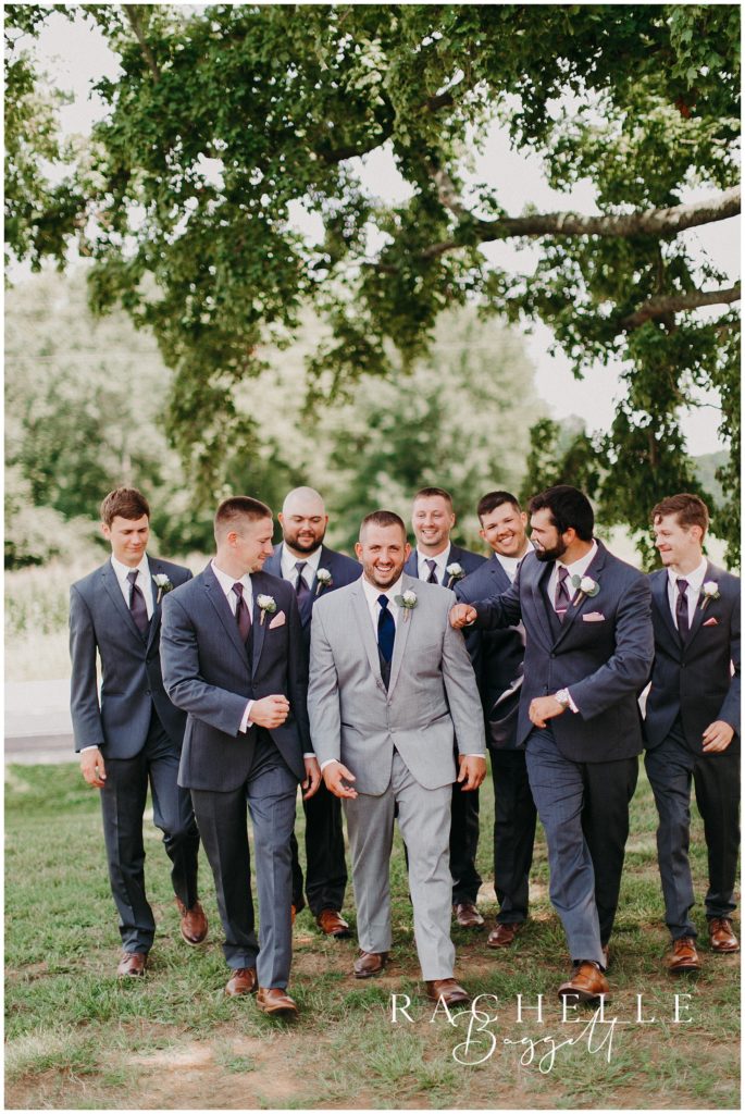 a groom walking with a group of guys smiling
