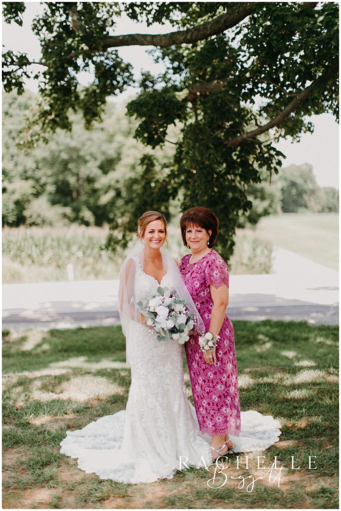 a bride and her mother smiles in a field. Evansville Wedding Photographer.