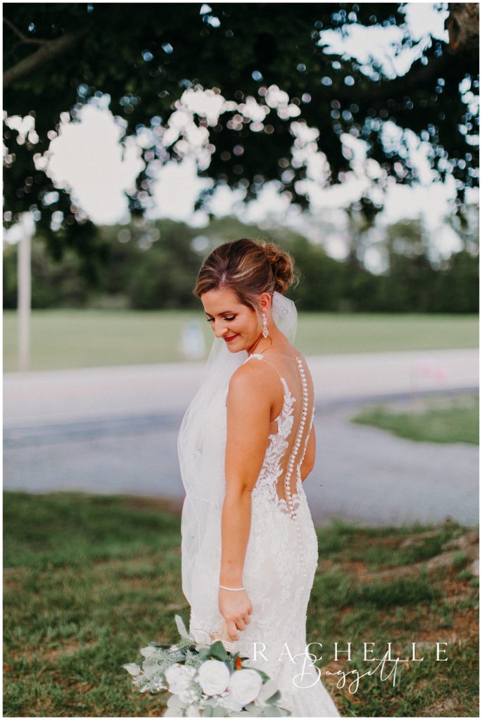 a bride smiles in a field. Evansville Wedding Photographer.