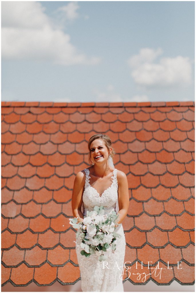 a bride smiles in front of a roof. Evansville Wedding Photographer.