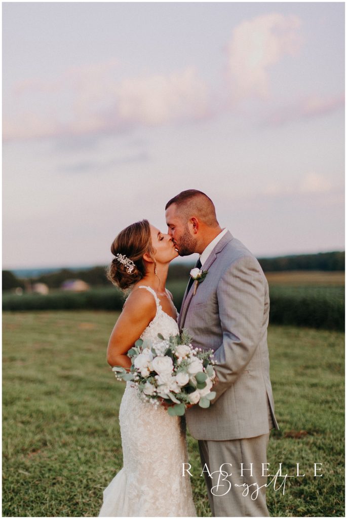 a man and woman kiss in a field. Evansville Wedding Photographer.