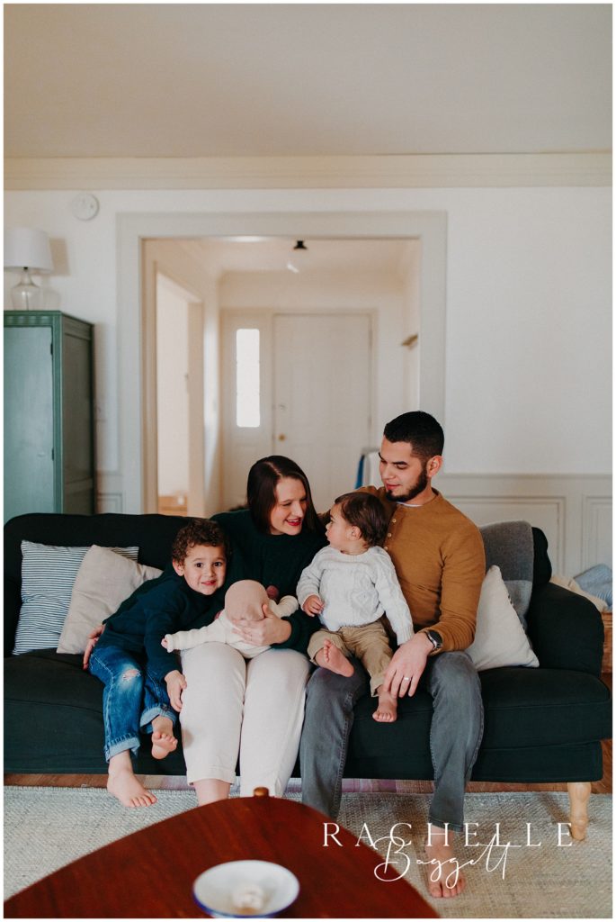 man and woman and three children sit on couch for cozy in-home family session