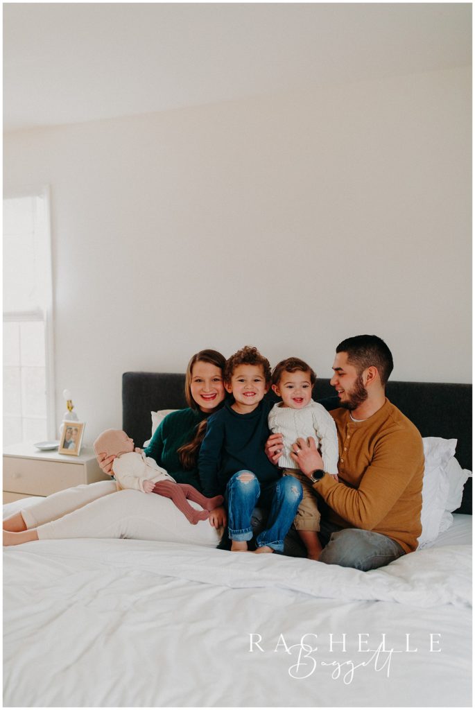 Man and woman with three children smiling, cozy in-home family session