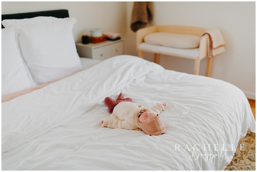 newborn baby girl on white duvet, cozy in-home family session