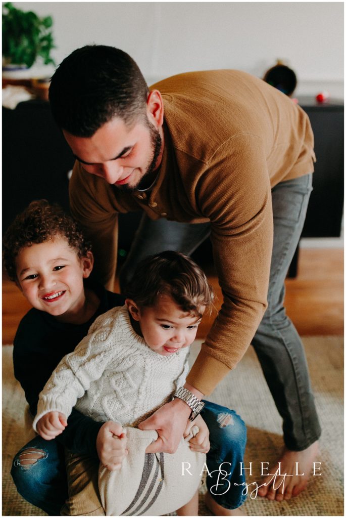 father playing with two sons in their new home, cozy in-home family session