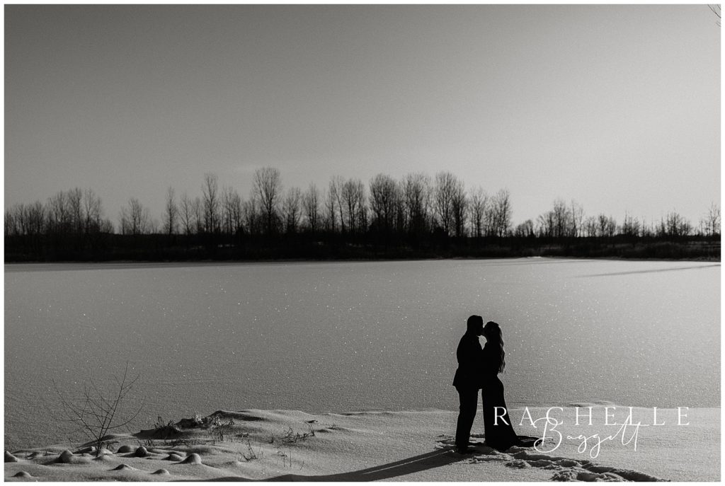 landscape black and white photo of couples silhouette sharing a kiss
