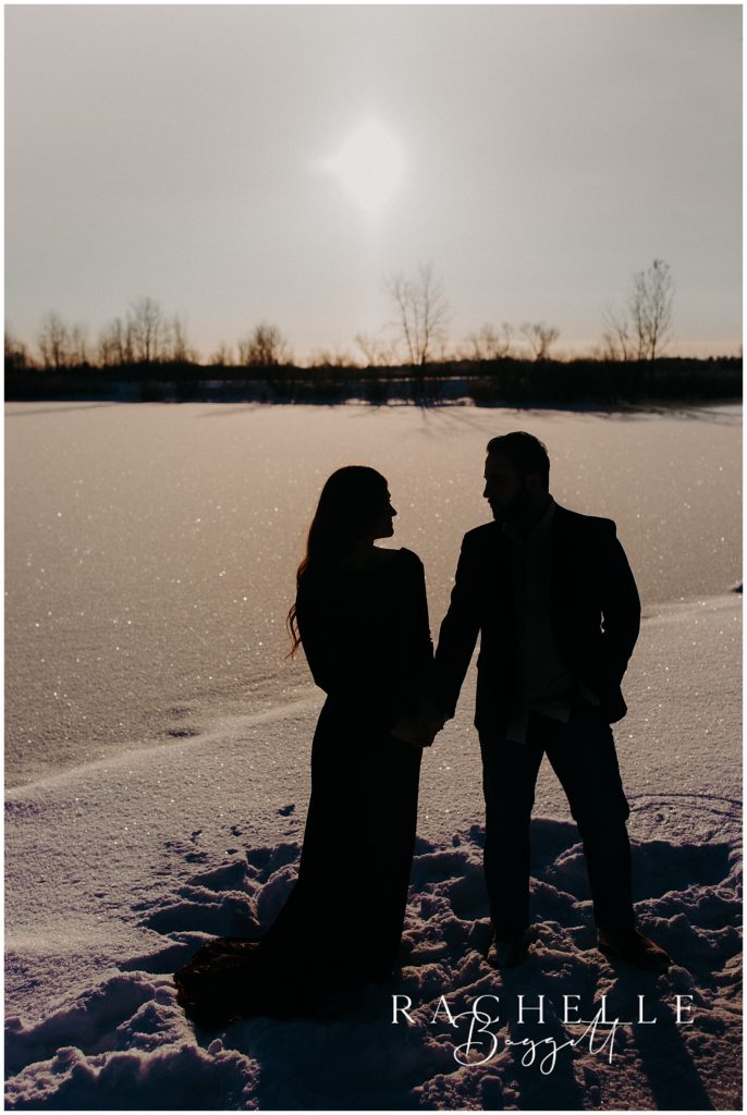 silhouette of couple during their snowy sunrise engagement session