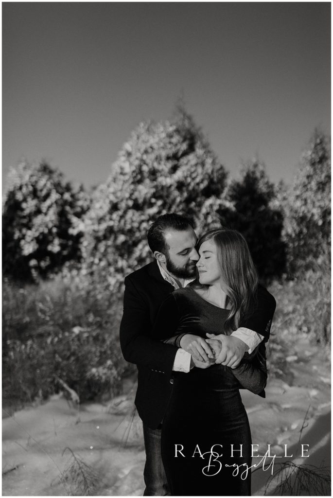 black and white photo of engaged couple embracing