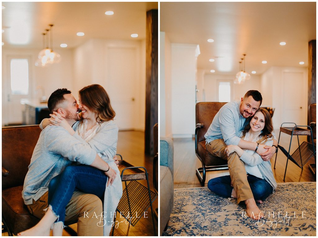 husband and wife smiling and sitting on brown leather chair in Downtown Loft Couples Session