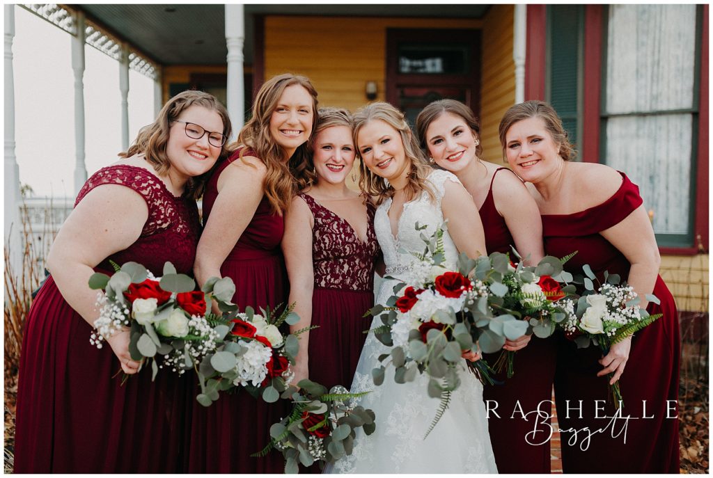 bride with bridesmaids outside yellow barn