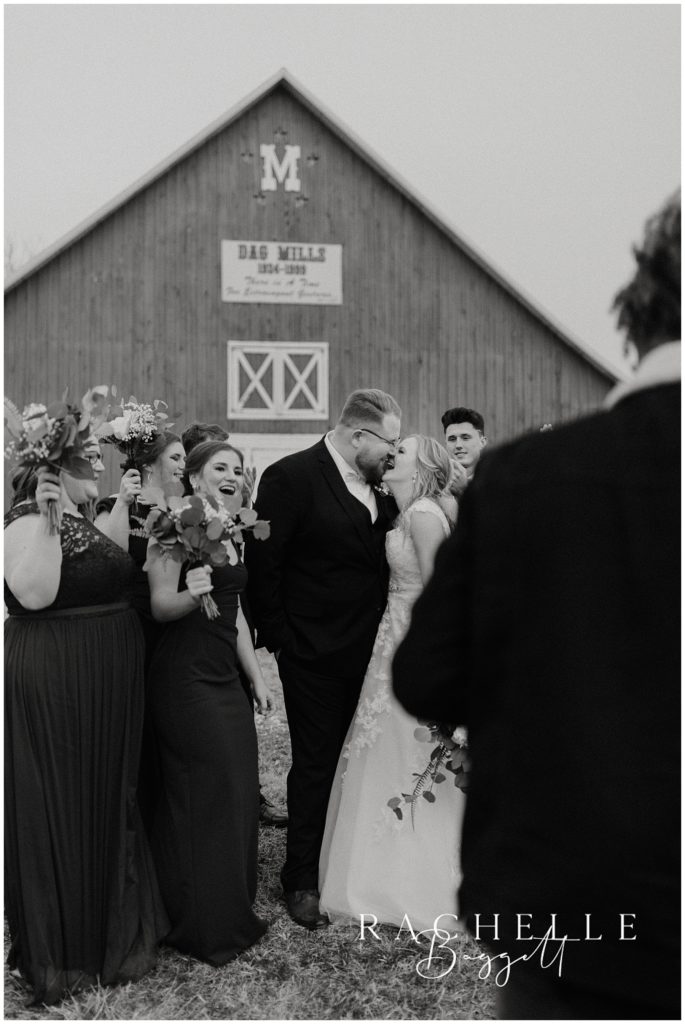 bride and groom share a kiss outside the venue