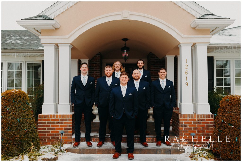 groomsmen and groom posing
