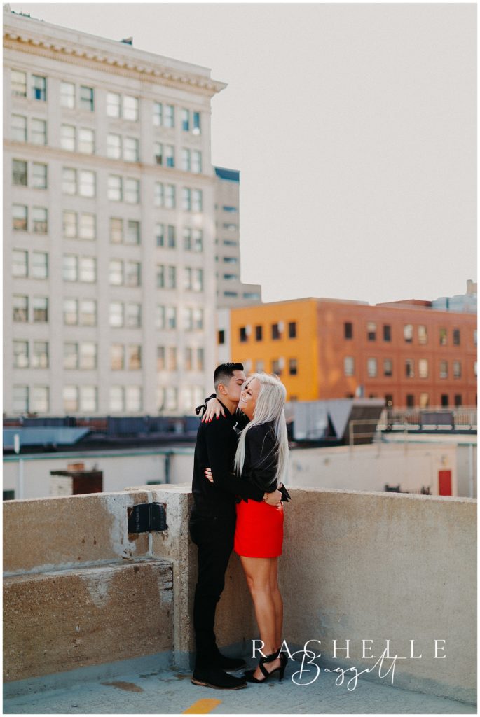 engaged couple embracing during rooftop engagement session