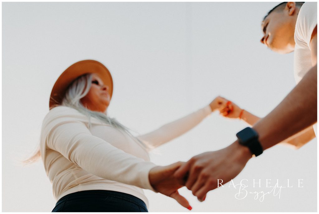 man and woman hold hands during engagement photo session