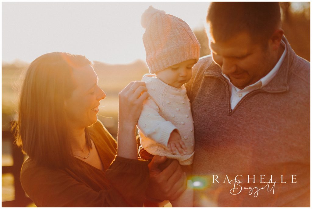 mom and dad hold daughter during Sunrise Family Session