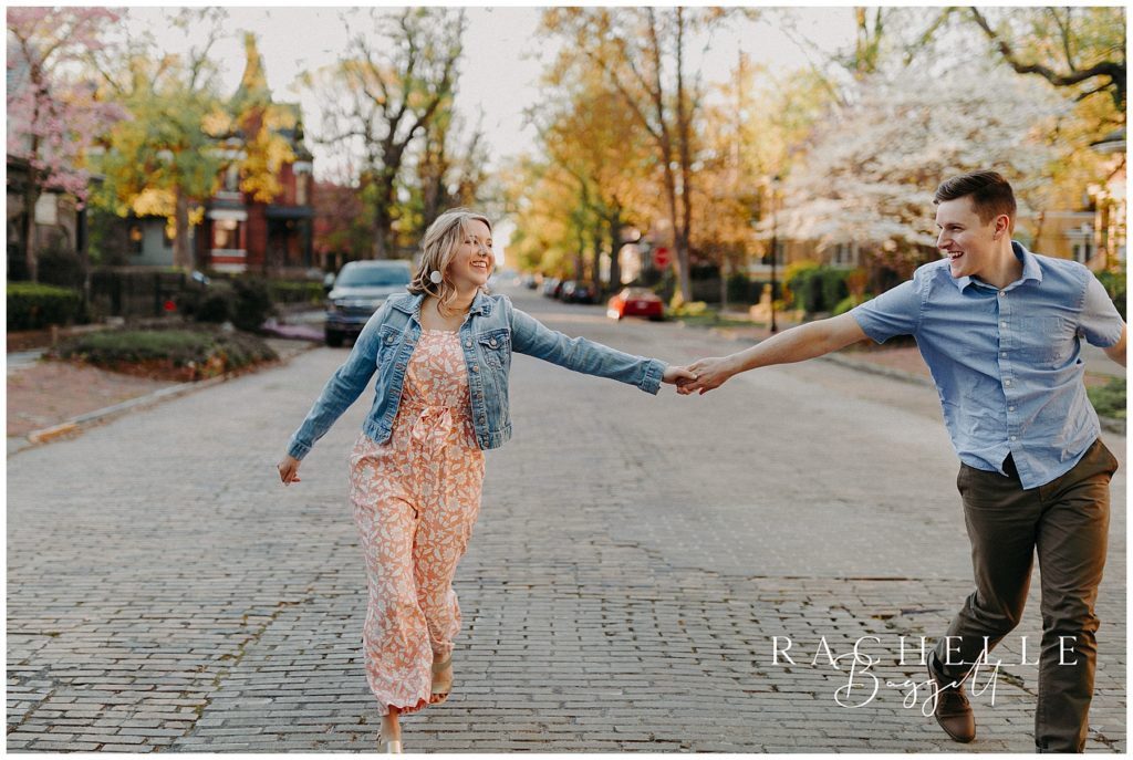 man and woman hold hands on old brick road