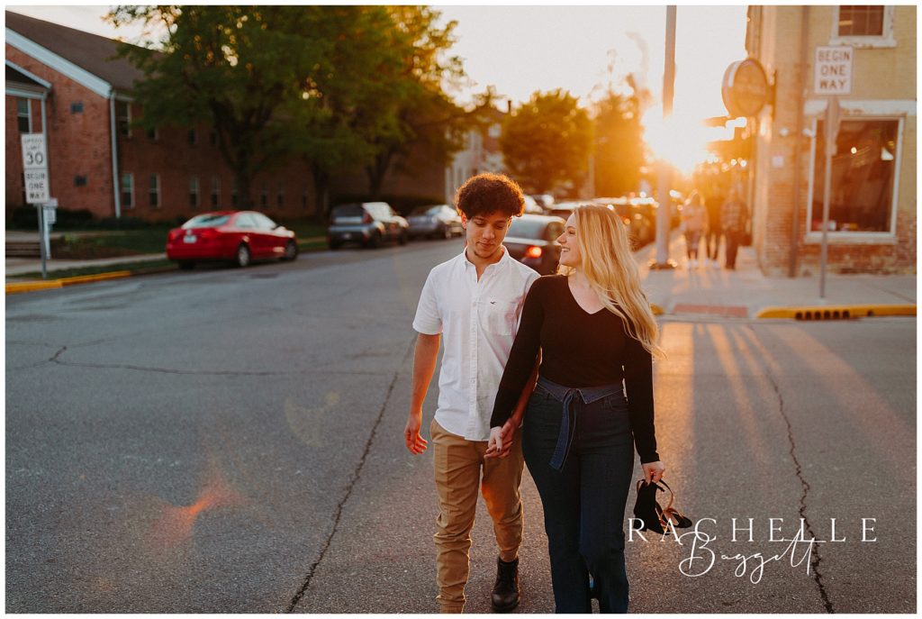 future married couple walk downtown during sunset