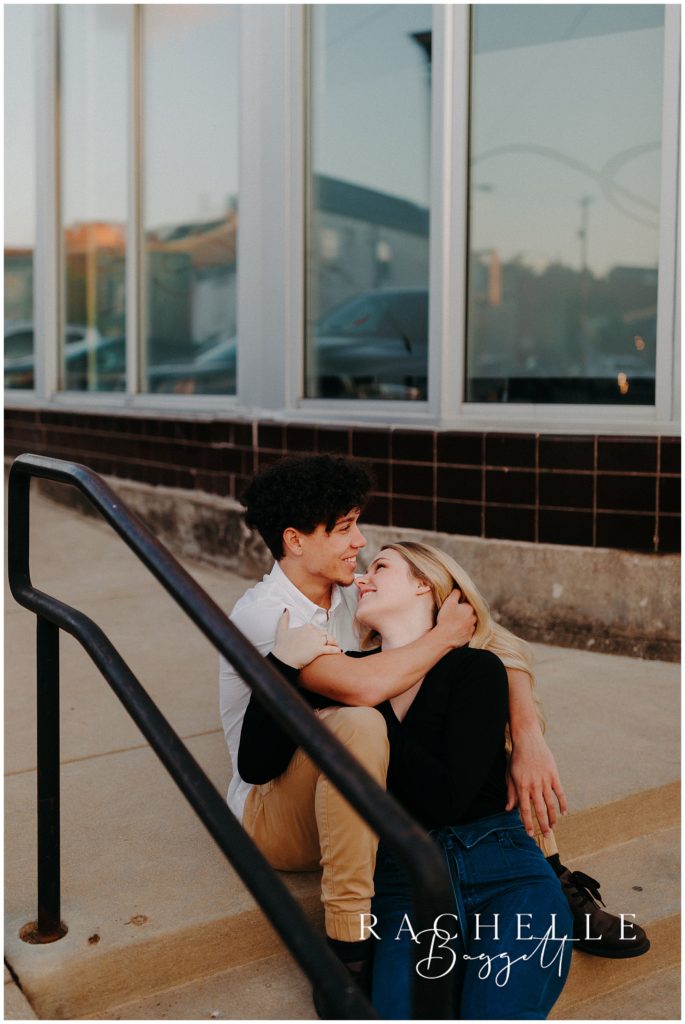 man and woman embrace while sitting on outdoor steps