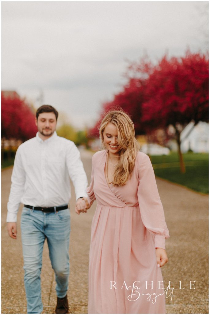 engaged couple walks outdoors near spring blooms in Vincennes, Indiana