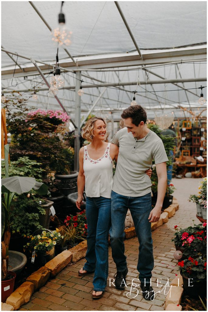 couple walking down aisles of greenhouse