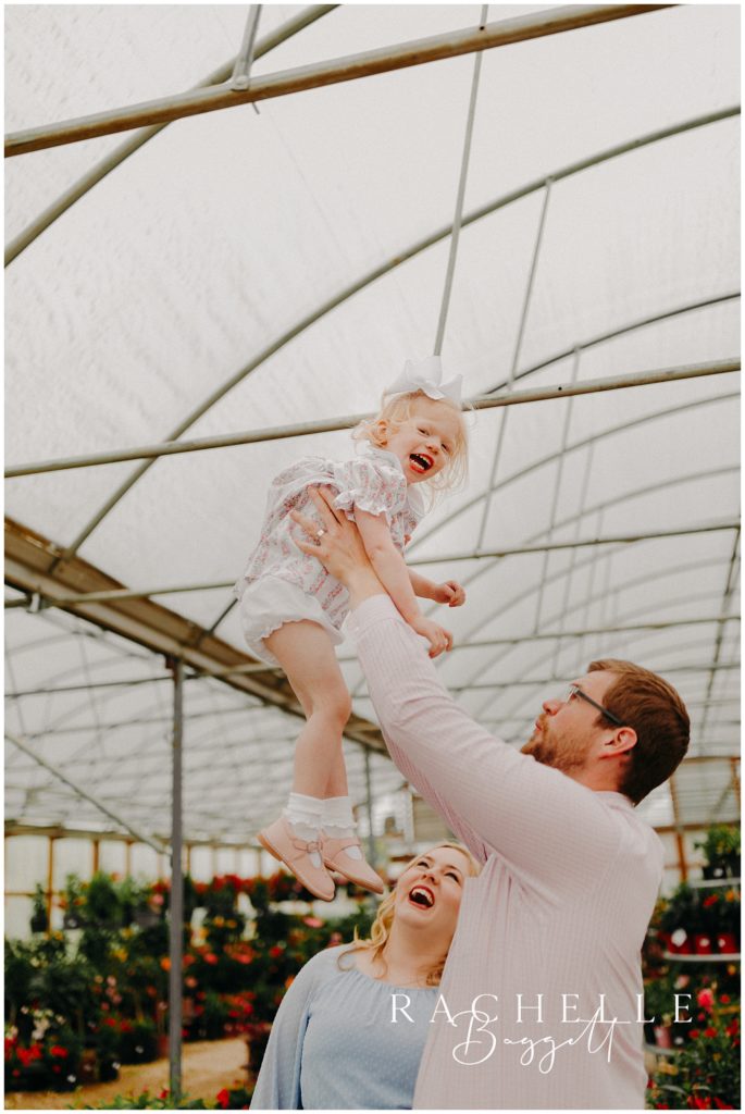 dad lifting daughter inside greenhouse