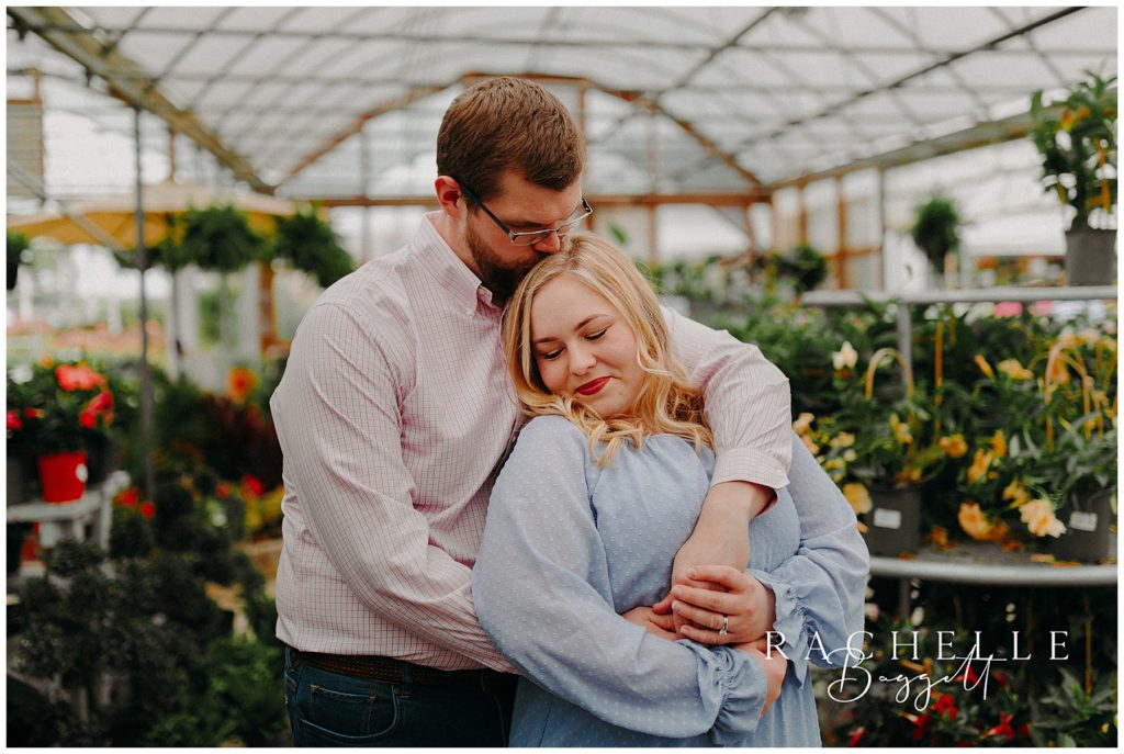 husband embracing wife in greenhouse