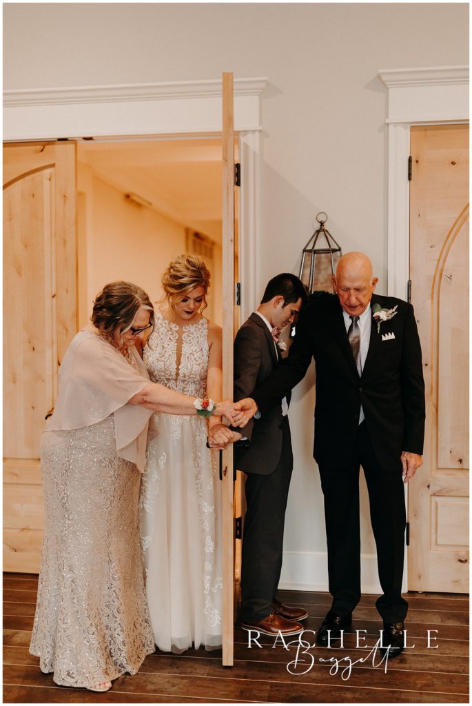 bride and groom having first touch and prayer with bride's grandparents